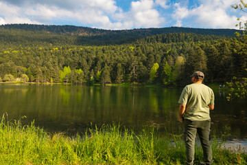 Fisher man fishing near the lake in the forest. Hobby or leisure activity photo