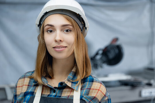 University Graduate Trainee Worker Of Modern Manufacturing Factory Blue Background. Portrait Young Woman Engineer In Hardhat