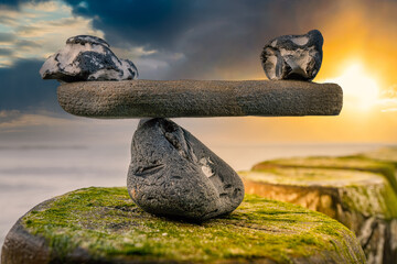 im Gleichgewicht der Kräfte - natürliche Wage aus Steinen am Meer - Symbolfoto