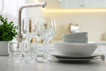 Different clean dishware and glasses on countertop in kitchen