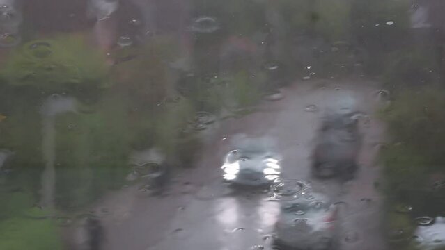 Regen prasselt auf ein Dachfenster