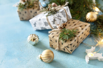 Fototapeta na wymiar Christmas balls, winter fir tree with present boxs and christmas decor on a blue stone background. Christmas and New Year concept. Copy space.