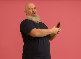 Fototapeta premium A joyful man with a gray beard holds a bump in his hands on a colored background. The concept of male potency