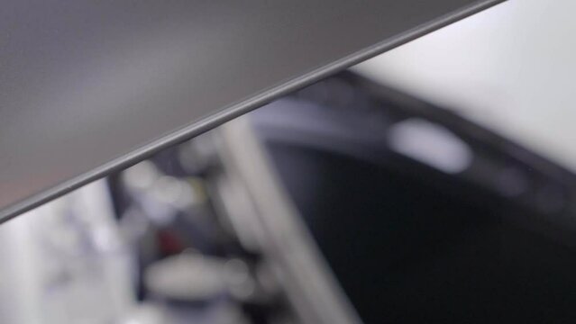 Hand Applying Paint Protection Film to Car's Exterior. Slow Motion CU.