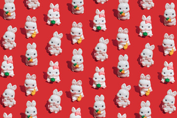 Seamless pattern made of little white rabbits on vibrant red background. Symbol of the Chinese New Year of the rabbit. Happy 2023 and good luck!