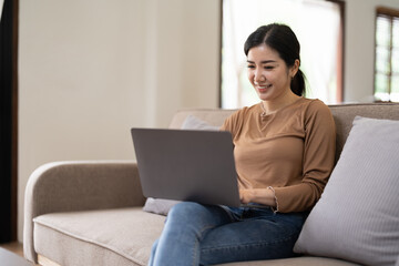 Young asian woman having conversation chatting while using laptop at house. Work at home, Video conference, Online meeting video call, Virtual meetings, Remote learning and E-learning