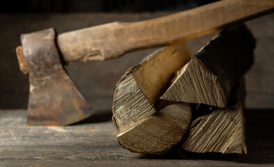 An ax is cut into a log of firewood for a firebox on a wooden texture