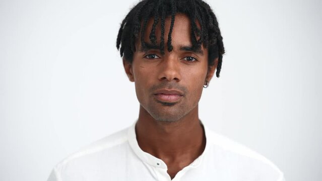 Serious African man with dreadlocks looking at camera in the white studio
