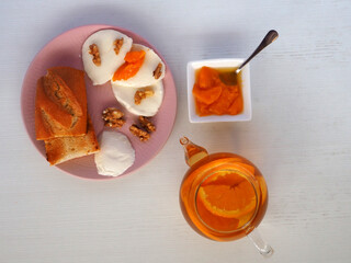 Still life with tasty peaches jam, mozzarella cheese, walnuts, orange tea