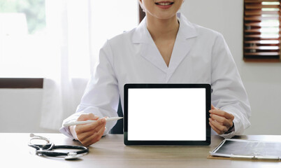 Portrait of experienced doctor woman cardiologist present modern technology white screen tablet she use consult patients wear white coat uniform stethoscope in examination room.