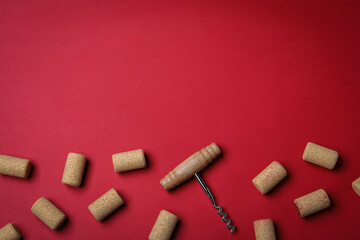 Corkscrew and wine bottle stoppers on red background, flat lay. Space for text