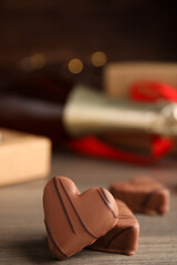 Obraz na płótnie Canvas Tasty heart shaped chocolate candies on wooden table, closeup. Happy Valentine's day