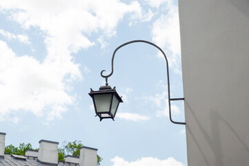 Fototapeta na wymiar Vintage street lamp on wall of building against blue sky, low angle view