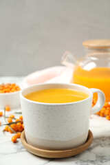 Delicious sea buckthorn tea on white marble table