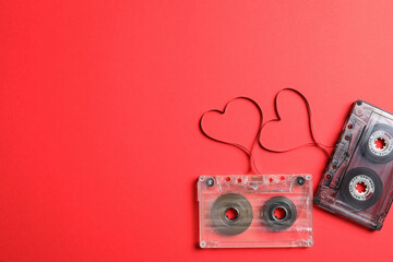 Music cassettes and hearts made of tape on red background, flat lay with space for text. Listening...