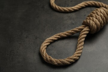 Rope noose with knot on grey table, closeup. Space for text