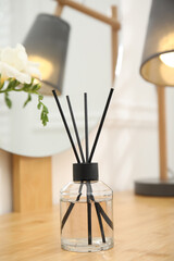 Aromatic reed air freshener on wooden table in room