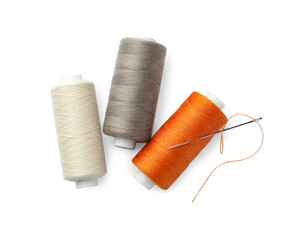 Different colorful sewing threads and needle on white background, top view