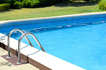 Swimming pool with metal ladder on sunny day