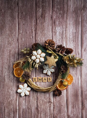 Christmas background. Handmade Christmas wreath with festive decorations on rustic wooden table. symbol of festive winter season. top view