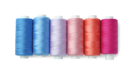 Set of different colorful sewing threads on white background, top view