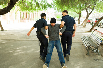 Police agents bringing a an upset angry homeless man to a shelter