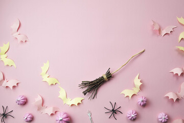 pink background with a place for text with small pink pumpkins with pink bats spiders skeletons broom witches, the concept of a creative happy Halloween
