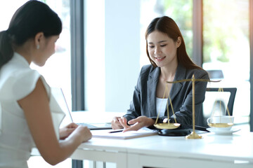 Business woman and lawyers discussing contract papers with brass scale on wooden desk in office. Law, legal services, advice, Justice concept