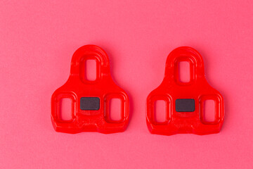 Cycling Ideas. Pair of New Red Cycling Cleats Over Pink Coral Background.