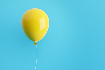 Yellow flying air helium balloon against blue background.