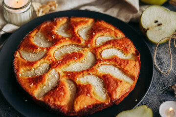 Cake with pear, honey and almonds. Delicious pie on a concrete table