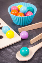 Colorful balls with spoon and tongs. Development of kids motor skills, coordination, creativity and logical thinking