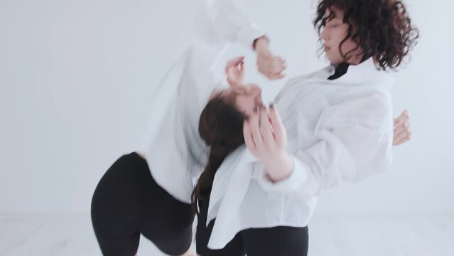 Two charming young girls in black and white clothes present an original contemporary dance. Contact improvisation