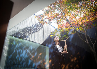 Female engineer with wind turbine model standing in courtyard