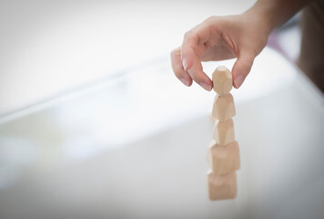 Close up hand of man stacking wooden pieces