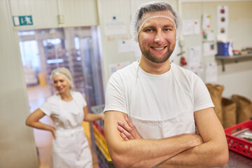 Young man as a proud baker with his arms crossed