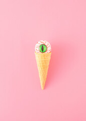 Creative aesthetic concept made of a cone and a bloody eye instead of a scoop of ice cream on a...
