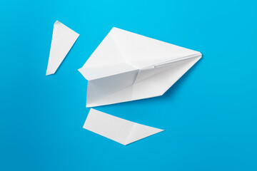 Cutting off the wings of an airplane, the concept of sanctions on Russian companies on a blue background due to the operation in Ukraine