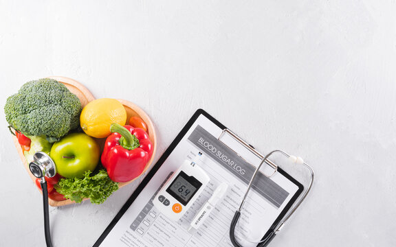 World Diabetes Day And Healthcare Concept. Diabetic Measurement Set, Patient's Blood Sugar Control And Healthy Food Eating Nutrition In Plate On Stone Background.