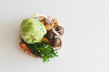 String bag with ingredients for preparing ukrainian borscht on white background. Top view
