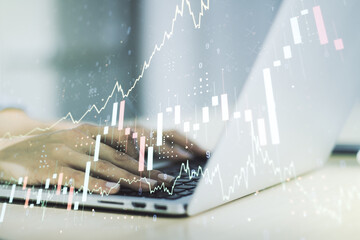 Double exposure of abstract creative financial chart with hand typing on computer keyboard on background, research and strategy concept