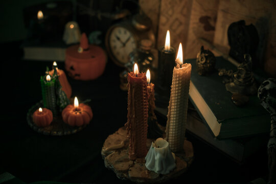 Illustration of magical stuff....candle light, magic wand, book of spells dark background, wizards school, green aesthetic, Halloween time
