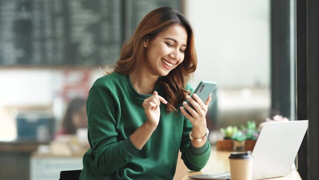 Young Asian women are enjoying using smartphone and social media application with pleasure and pleasure at the office.