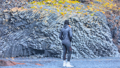 Beautiful girl watching Reynisdrangar rock formations and black beach - Vik, Iceland