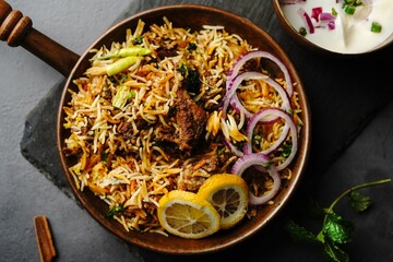 Hyderabadi Mutton goat biryani served with yogurt raita on moody setting
