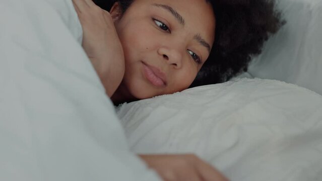 Woman in bed snooze alarm on phone, sleep on pillow after stop notification or buzz while home. Girl awake from noise on smartphone in bedroom, end sound and rest, on weekend or holiday