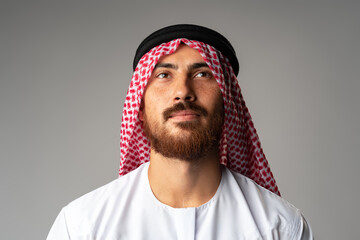 Portrait of young Arab man on gray background in studio