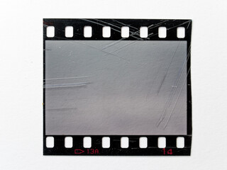 scratched empty 35mm filmstrip or snip on white paper background. cool film photo placeholder.