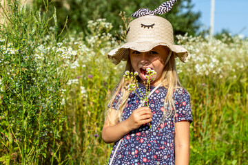 portrait of a beautiful girl on a background of a flowering rapeseed field