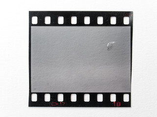 scratched empty 35mm filmstrip or snip on white paper background. cool film photo placeholder. 135...